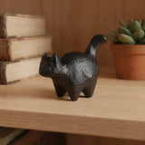 Black cast iron cat paperweight on a wooden shelf with books and plant, SKU GB78102