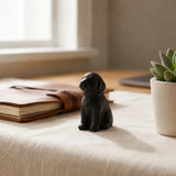 Black cast iron puppy paperweight on a desk with notebook and plant, SKU GB78103