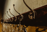 Row of vintage metal wall hooks on a rustic wall