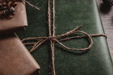Gifts wrapped in green and kraft paper tied with jute twine