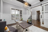Modern farmhouse room with sliding barn doors, wood beams and a farmhouse table