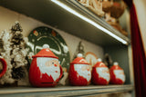 Holiday gift shop shelf display with Santa mugs and miniature Christmas trees