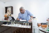 Shop owner using a calculator at the counter of a small boutique to work out retail prices