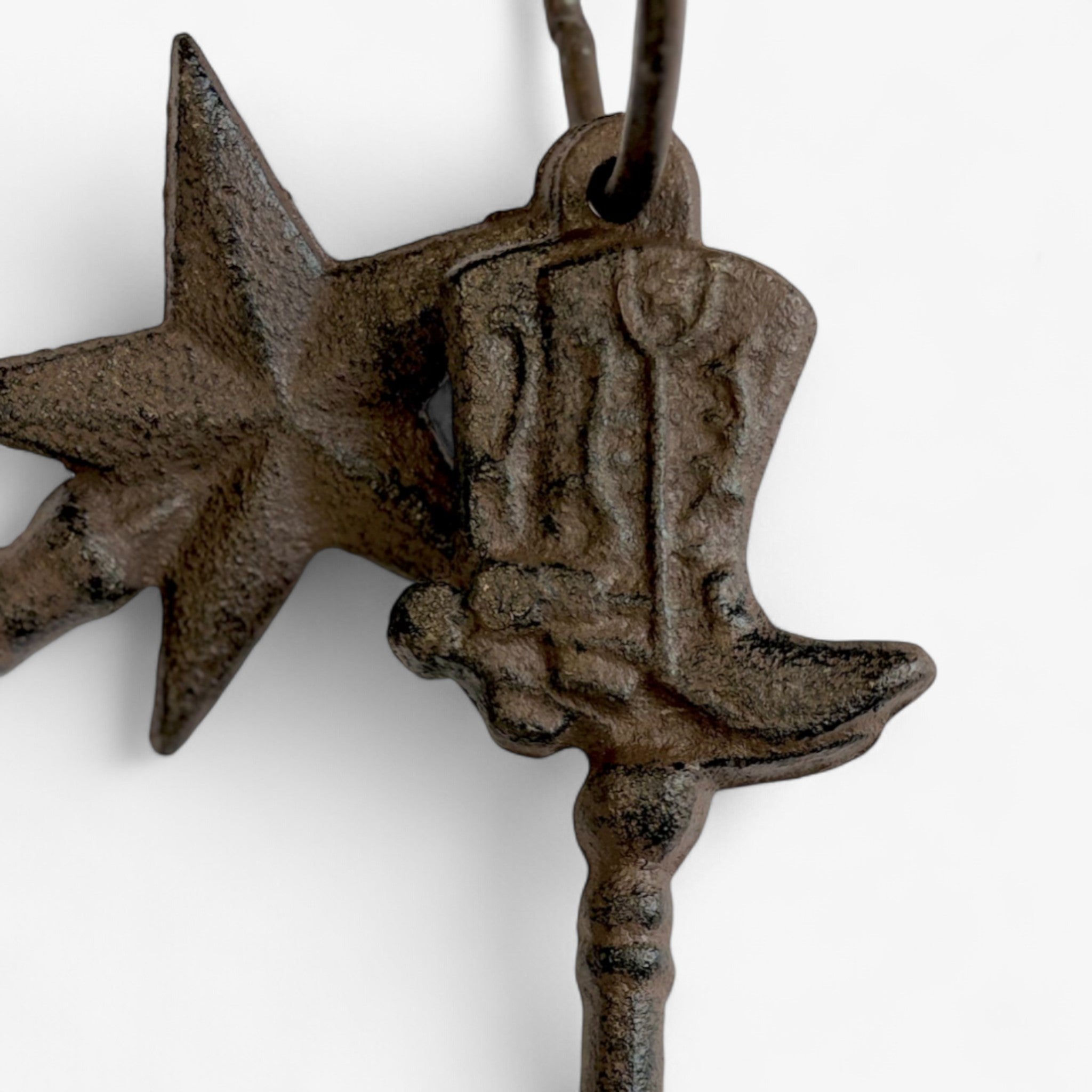Close-up of cast iron horse charm and star ornament showing hand-cast texture and rust patina