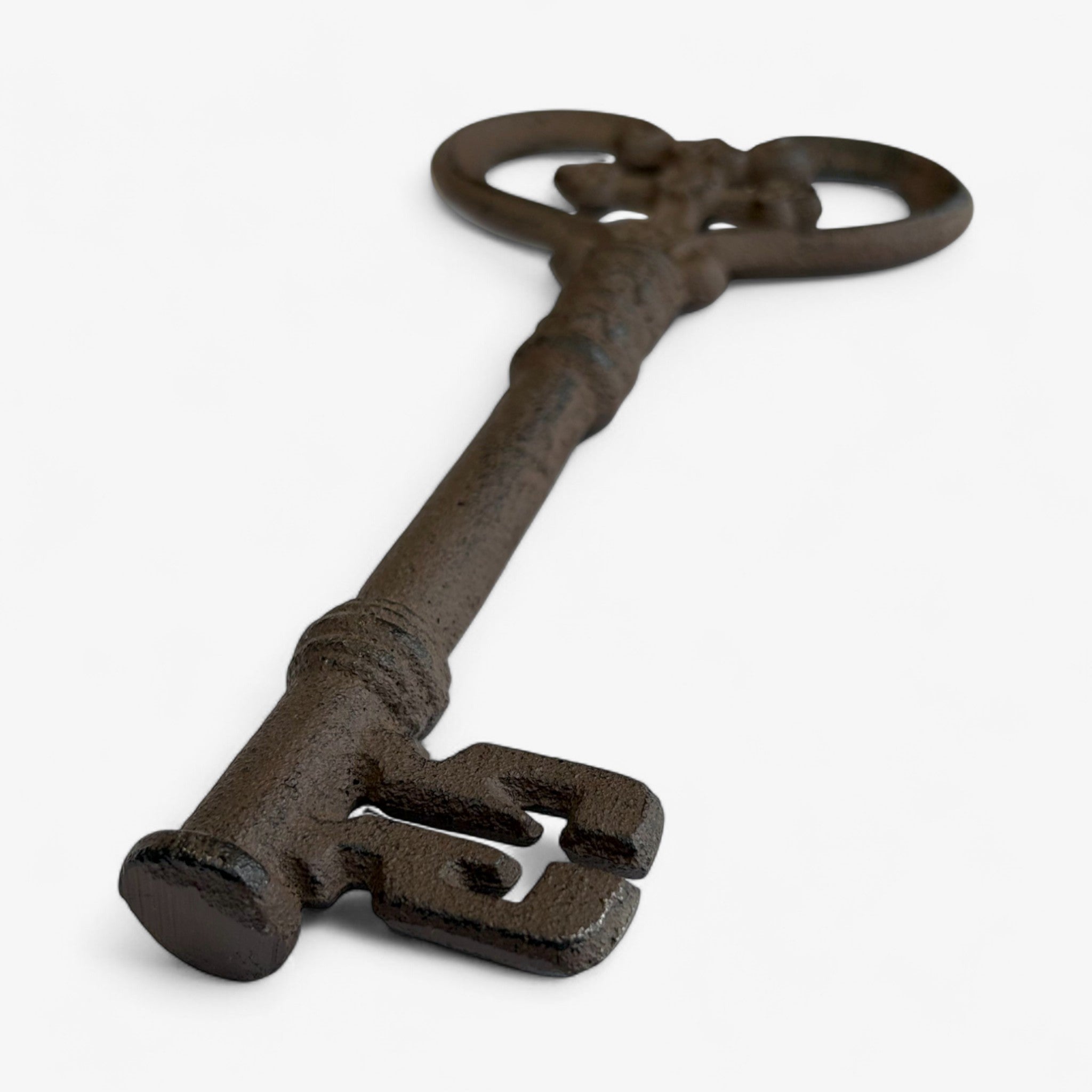 Vintage-style cast iron key with scrolled heart loop and weathered bronze finish