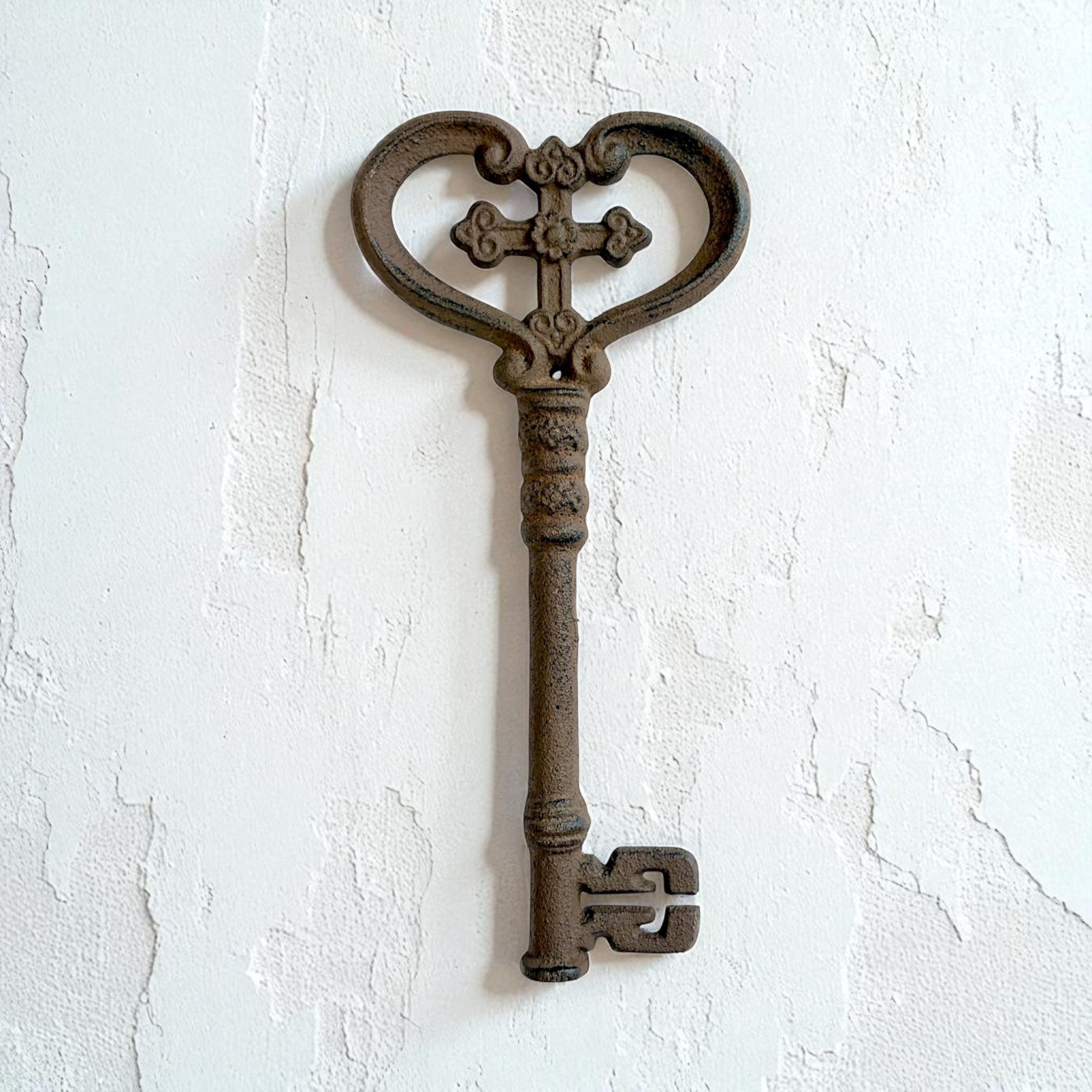 Antique bronze cast iron skeleton key with ornate heart and cross design