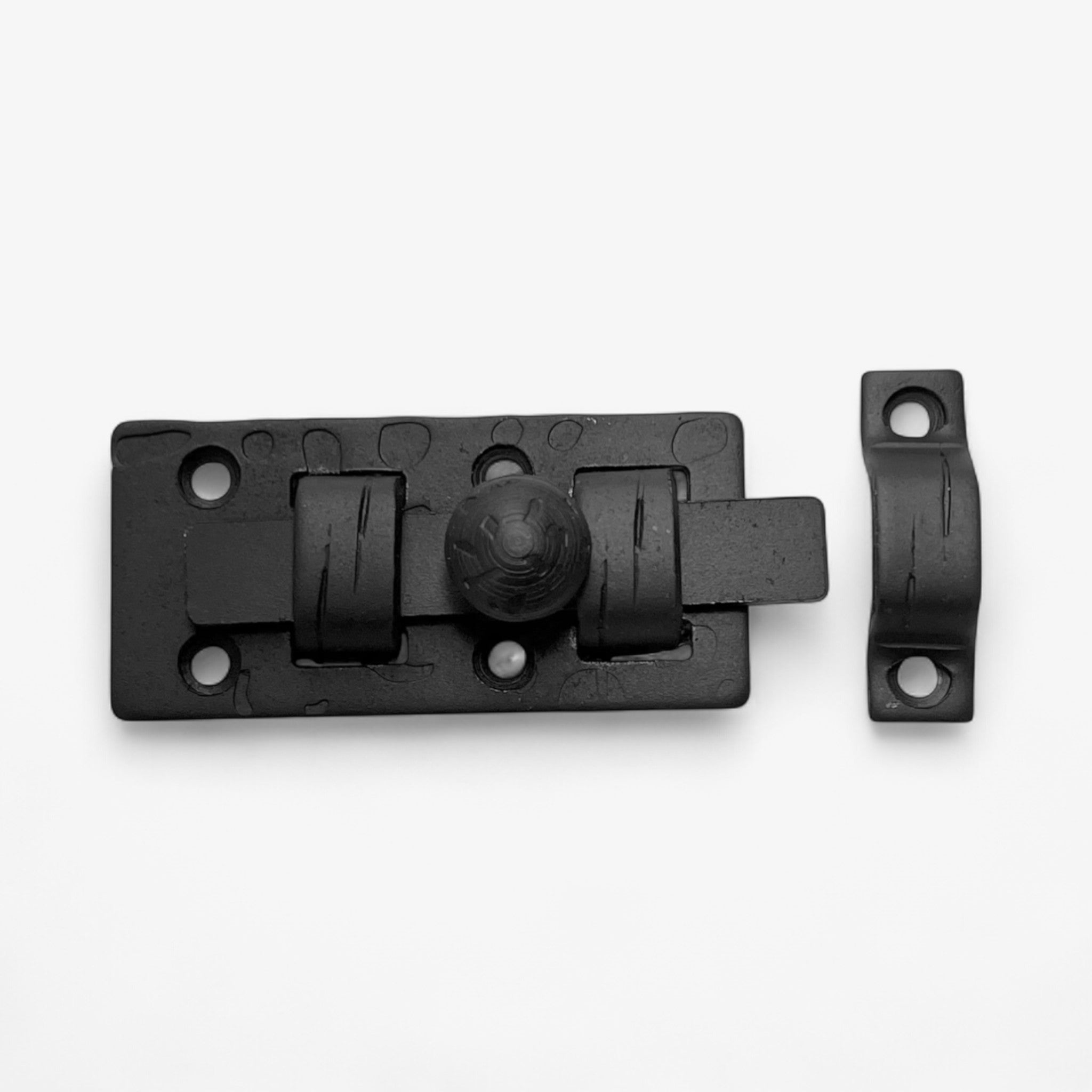 Black cast iron slide bolt lock with keeper plate, antique door hardware components isolated