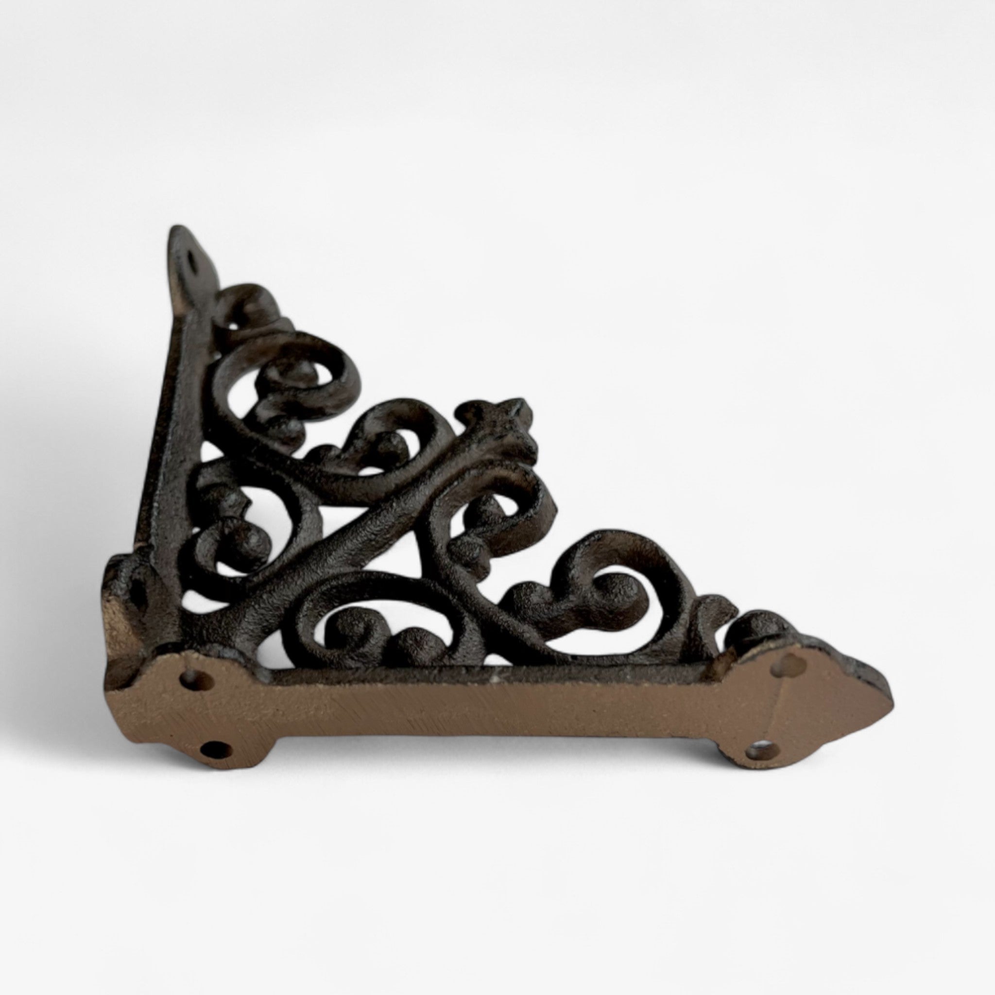 Vintage cast iron scroll bracket mounted on wood shelf, ornamental curved supports