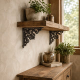 Rustic wood wall shelf with black cast iron decorative brackets and potted plants
