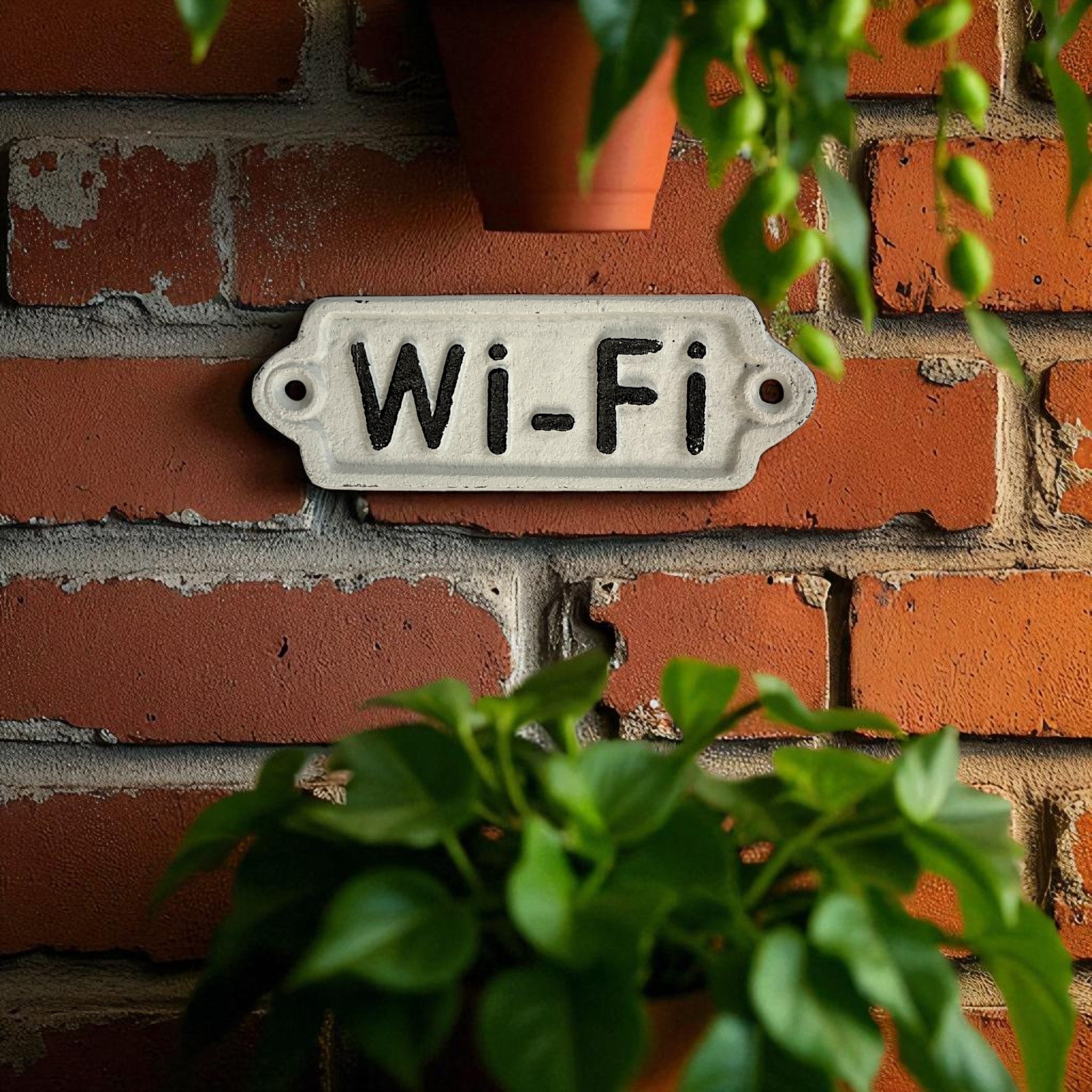 Vintage enamel Wi-Fi sign on red brick wall with weathered cream-white cast iron finish