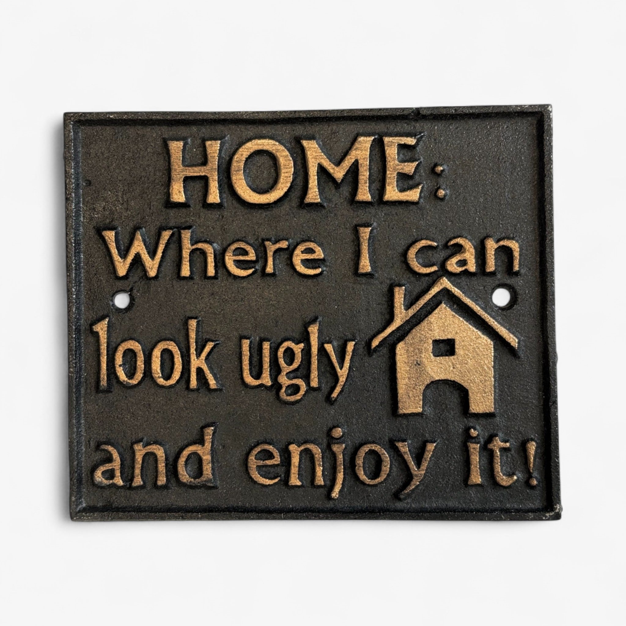 Vintage black cast iron humorous home sign with gold lettering, isolated studio shot