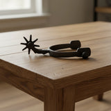 Western cast iron spur with star rowel and curved shanks, antique charcoal rustic finish