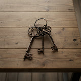 Antique cast iron skeleton key set with ornate handles and worn bronze finish on wood
