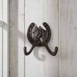 Cast iron horseshoe with detailed horse head design and double curved coat hooks