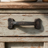 Rustic cast iron drawer pull with 1388 embossing on a distressed cabinet drawer