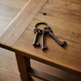 Trio of bronze cast iron antique keys on wooden table, vintage home accent