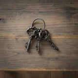 Set of three ornate cast iron vintage keys with decorative scrollwork on bronze metal ring