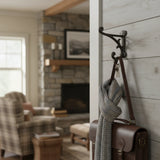 Rustic cast iron farmhouse hook with ornamental scroll design, dark brown finish on shiplap wall