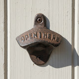 Cast iron bottle opener with Open Here embossed text and rustic brown weathered finish wall mount