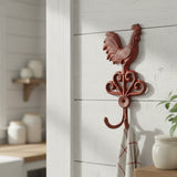 Red cast iron rooster hook with ornate base, rustic farmhouse kitchen decor