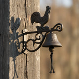 Rustic cast iron rooster doorbell with ornate scrollwork bracket and weathered finish