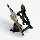 Cast iron cow welcome sign side view with black painted cow, leather strap, and decorative bell