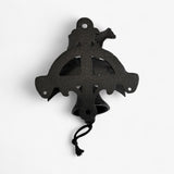 Decorative cast iron cross pendant with ornate cutout design and rope hanging loop in black finish