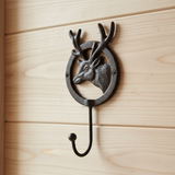 Cast iron deer head wall hook with antlers mounted on wood, rustic woodland home decor