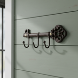 Decorative cast iron key organizer mounted on shiplap wall, dark metal finish
