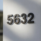 Rustic modern cast iron house numbers displaying 5632 with metallic patina finish mounted on white wall