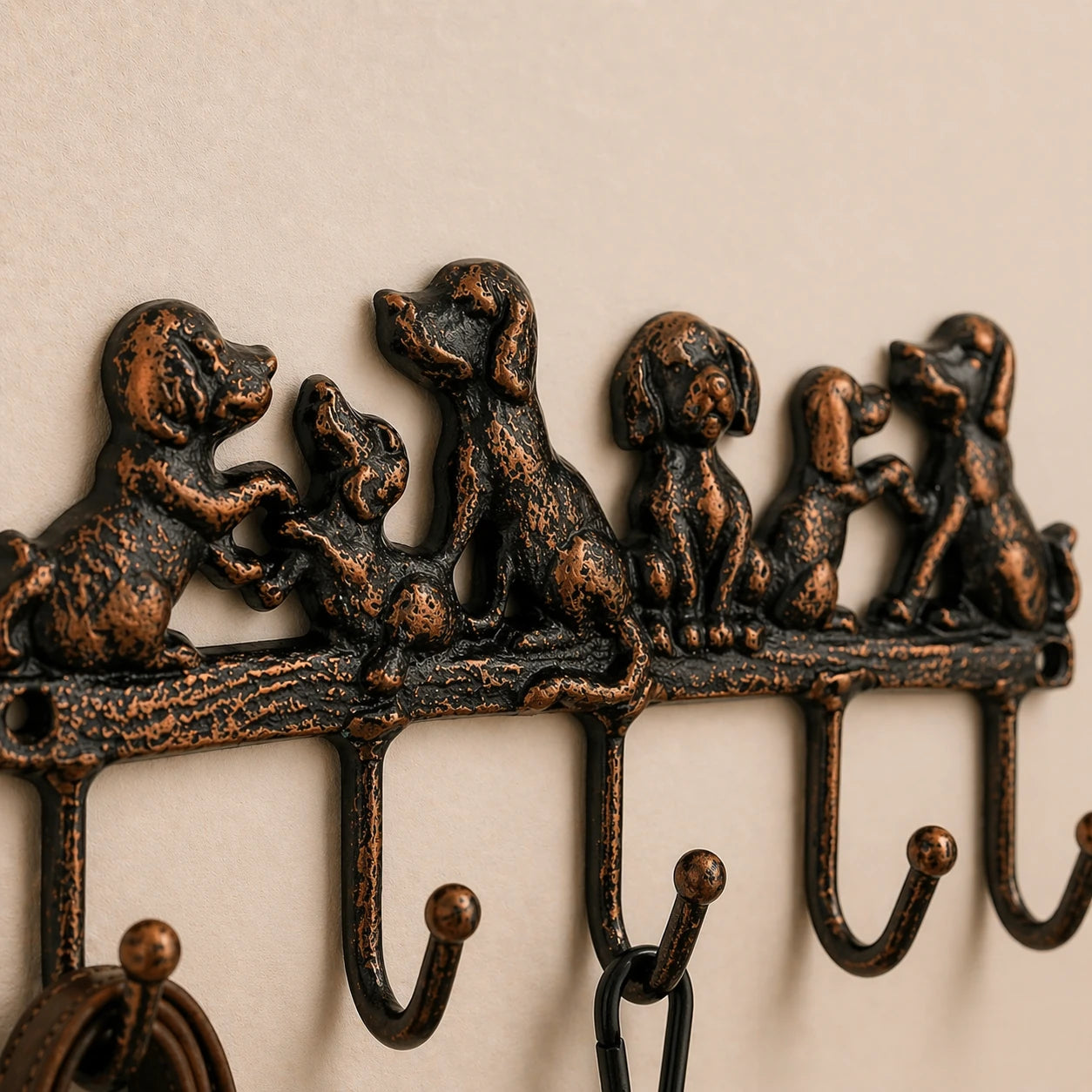Close view of cast iron dog family hook rack with five hooks.