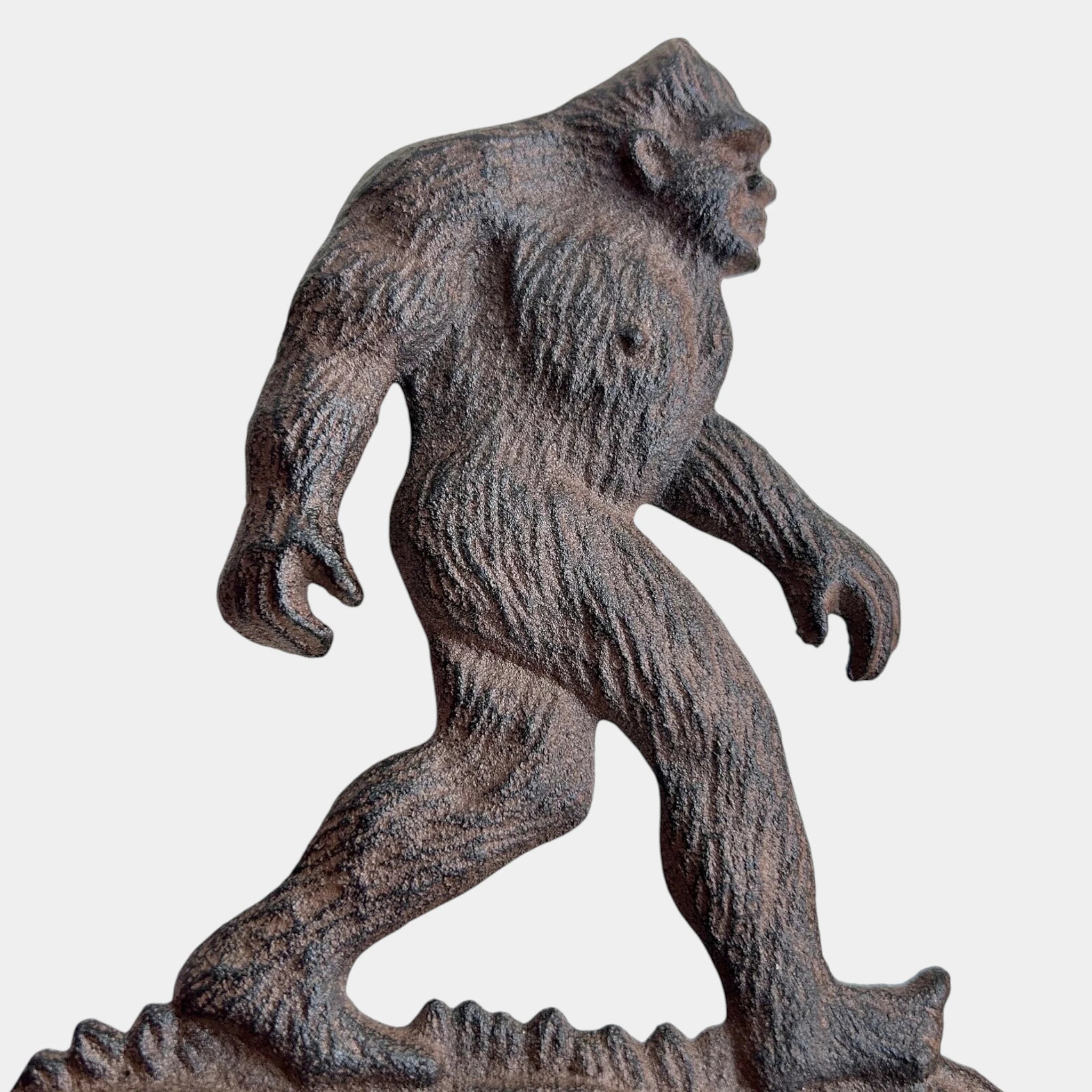 Bigfoot doorbell rustic cast iron sasquatch figure bell on weathered wood porch mounting