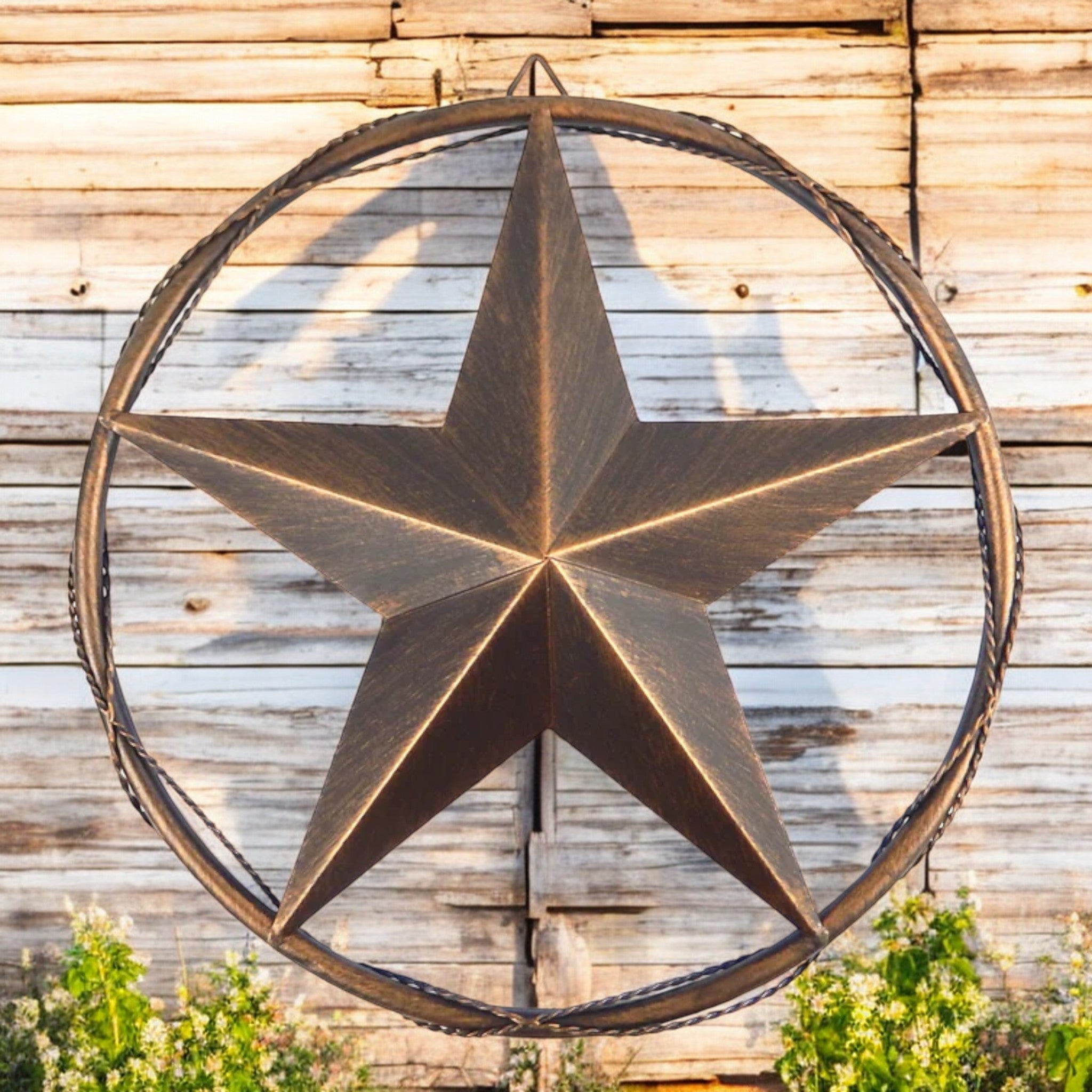 Twisted wire-accent barn star with brushed copper finish mounted on weathered wooden barn wall