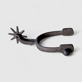 Cast iron cowboy spur with 8-point star wheel, weathered gray metal frontier wall accent