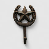 Dark aged cast iron star and horseshoe wall hook on white shiplap, functional decor