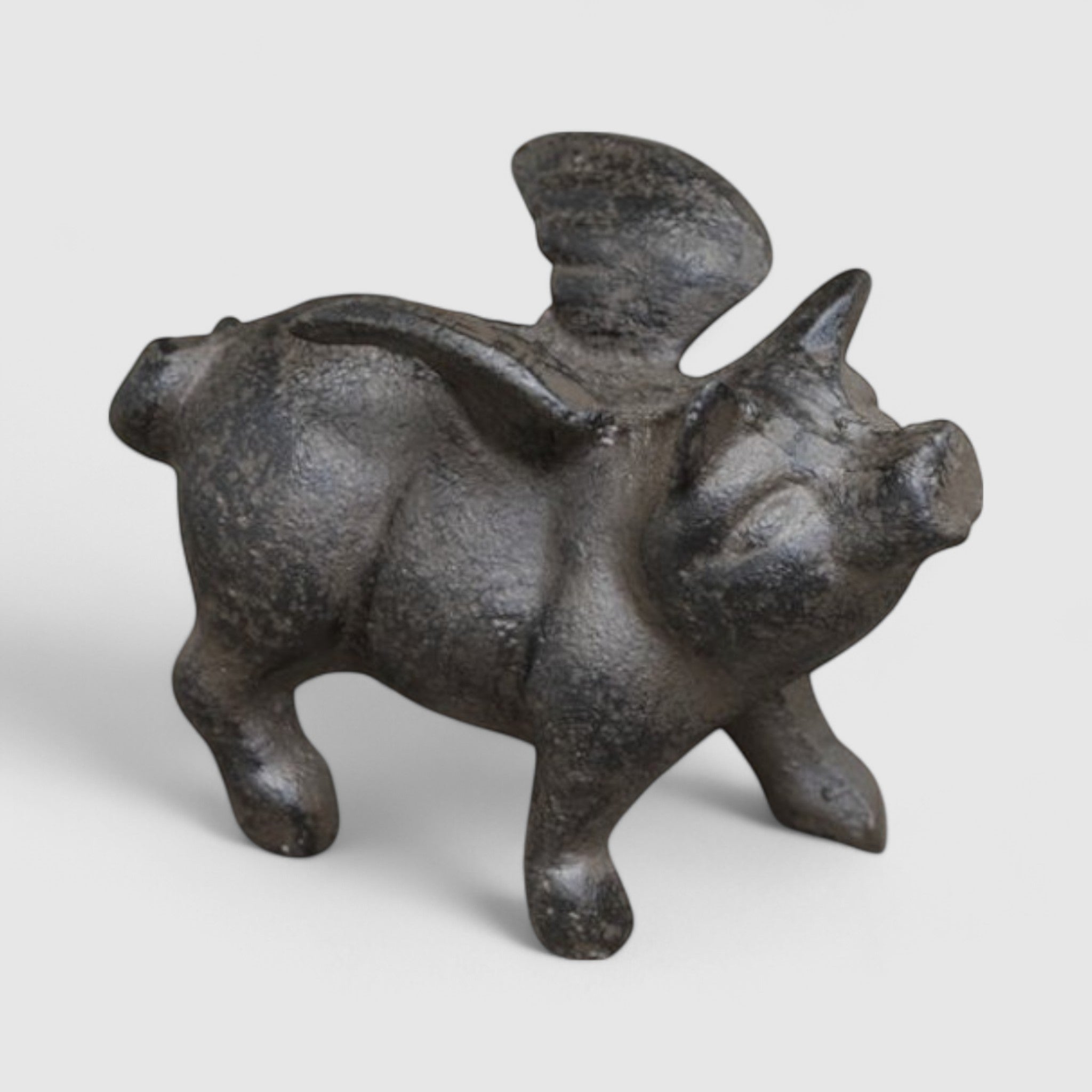 Dark cast iron flying pig figurine with detailed wings and textured finish shown from side