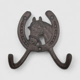 Horse head horseshoe coat hanger cast iron, dark textured finish mounted on white wood