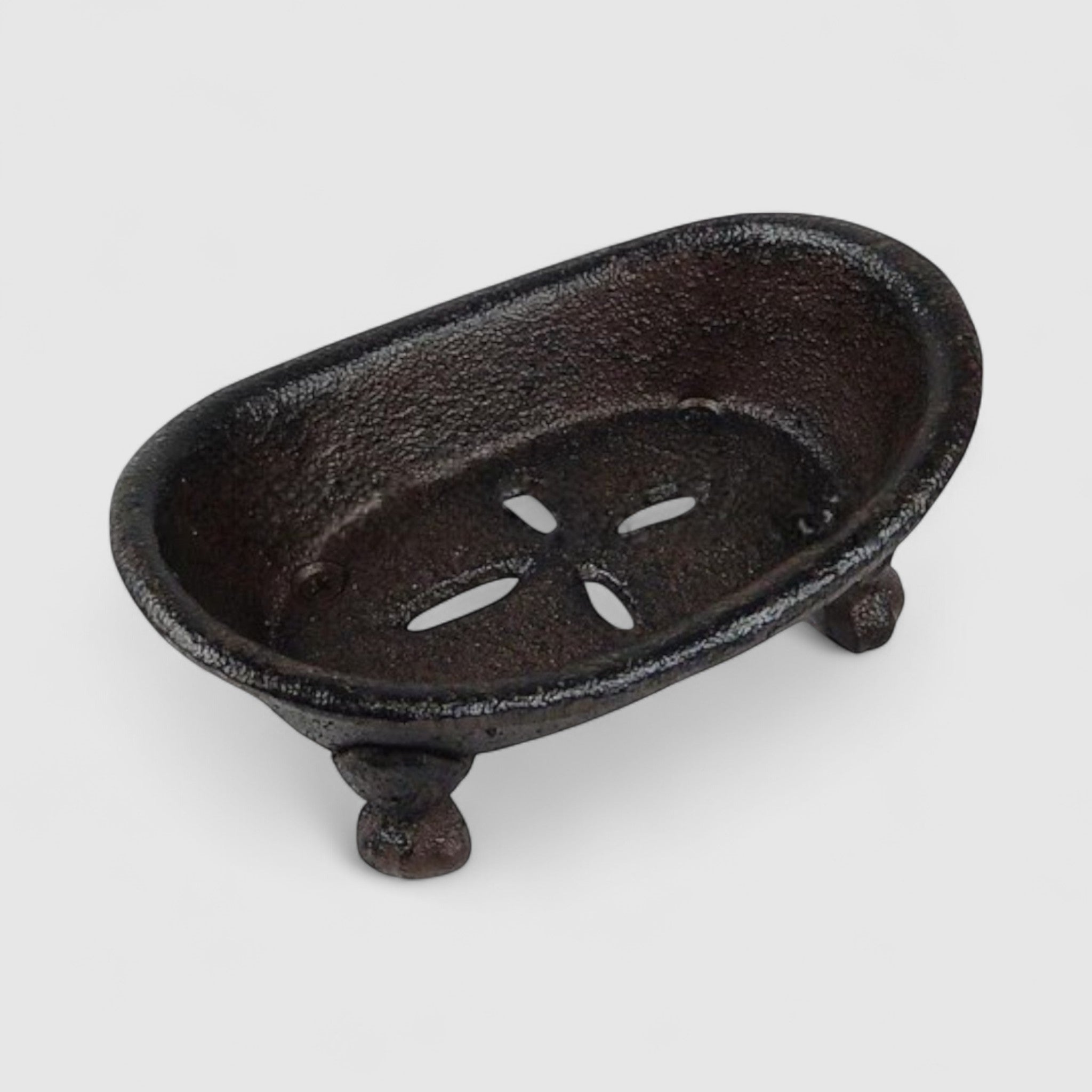 Vintage cast iron soap dish with drainage holes and decorative claw feet, dark finish