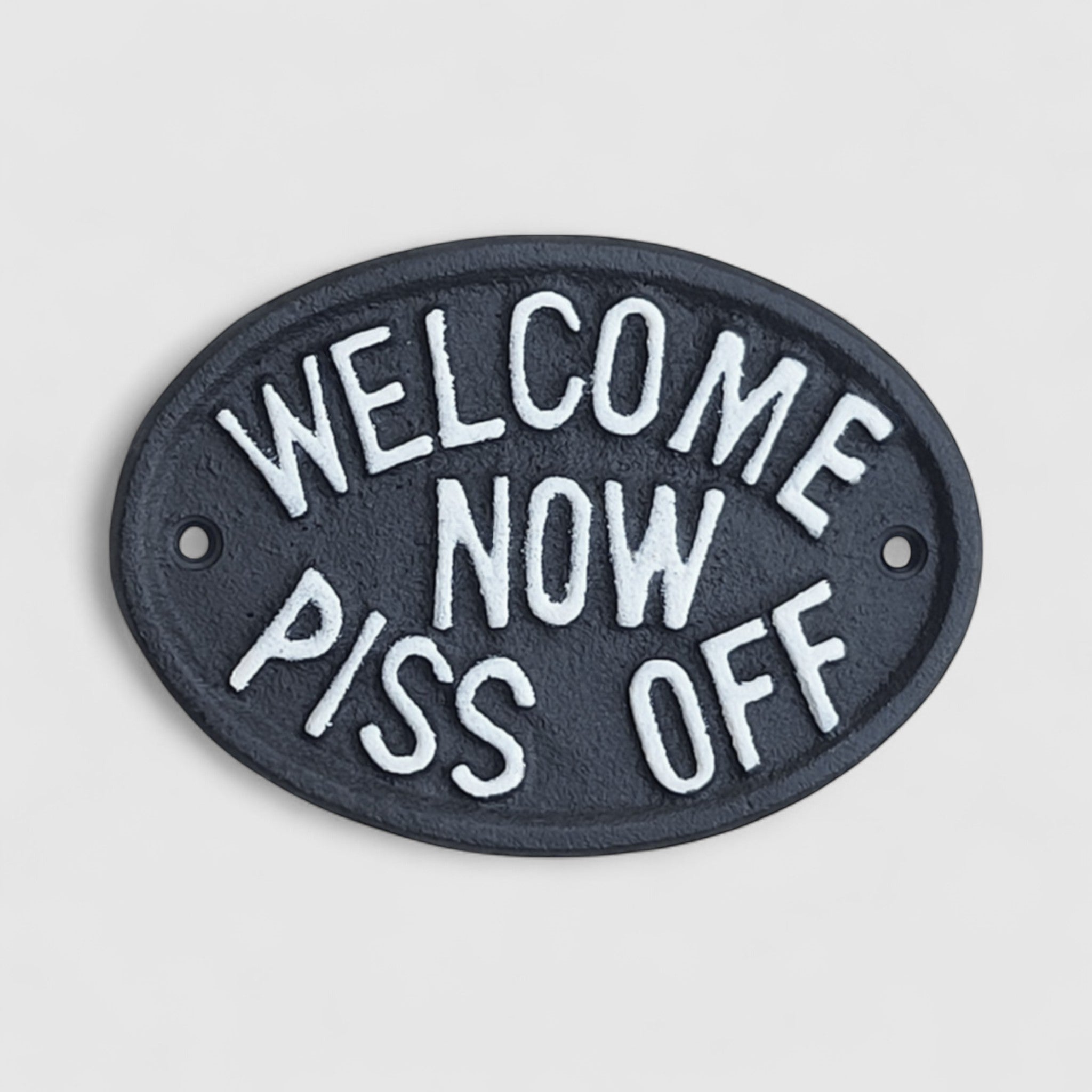 Black cast iron humorous welcome plaque with white raised lettering, rustic farmhouse decor