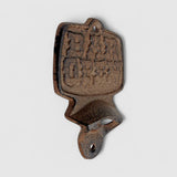 Antique cast iron bottle opener, weathered rust-brown patina, decorative tavern piece