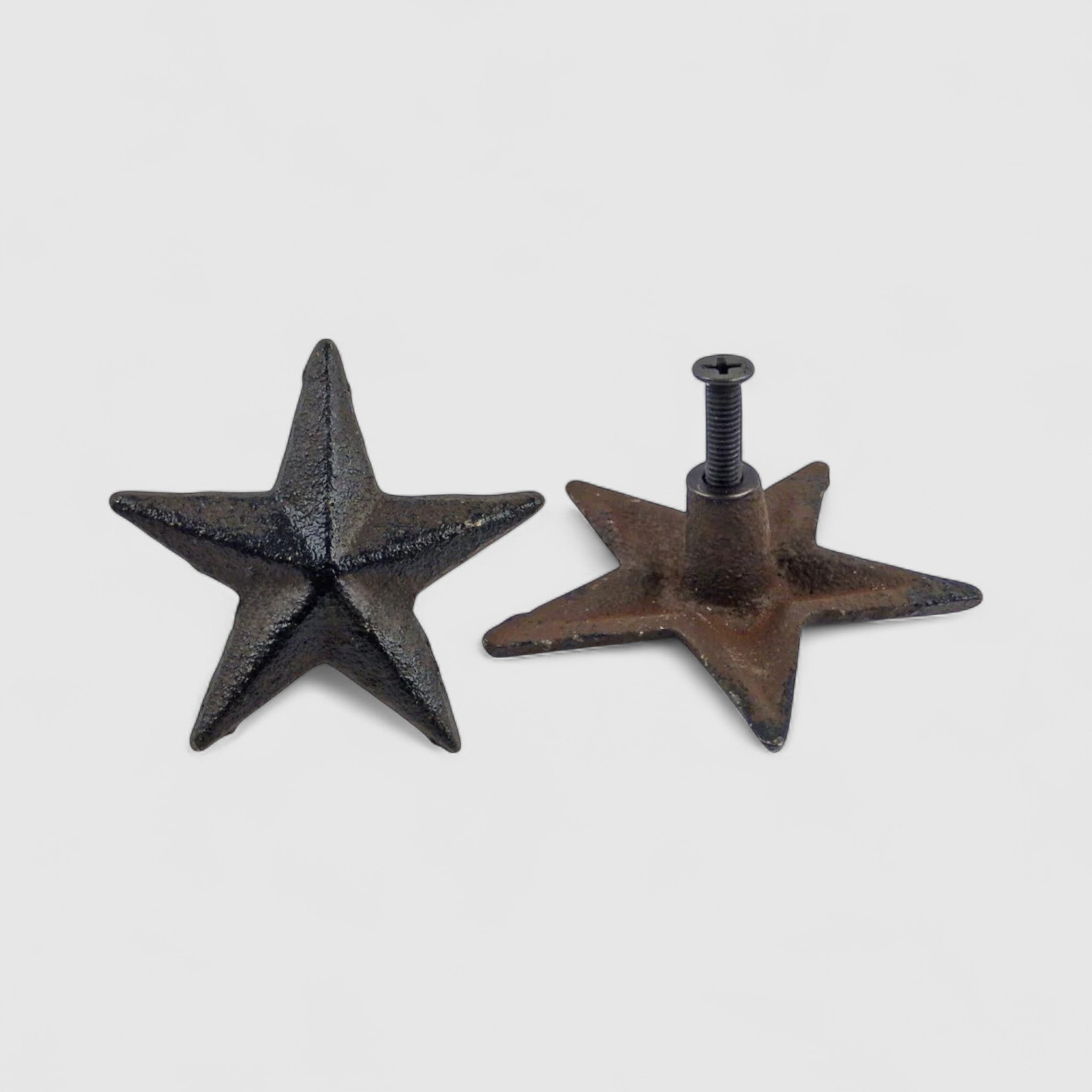 Two cast iron star knobs side-by-side, black and bronze finishes showing scale and hardware detail