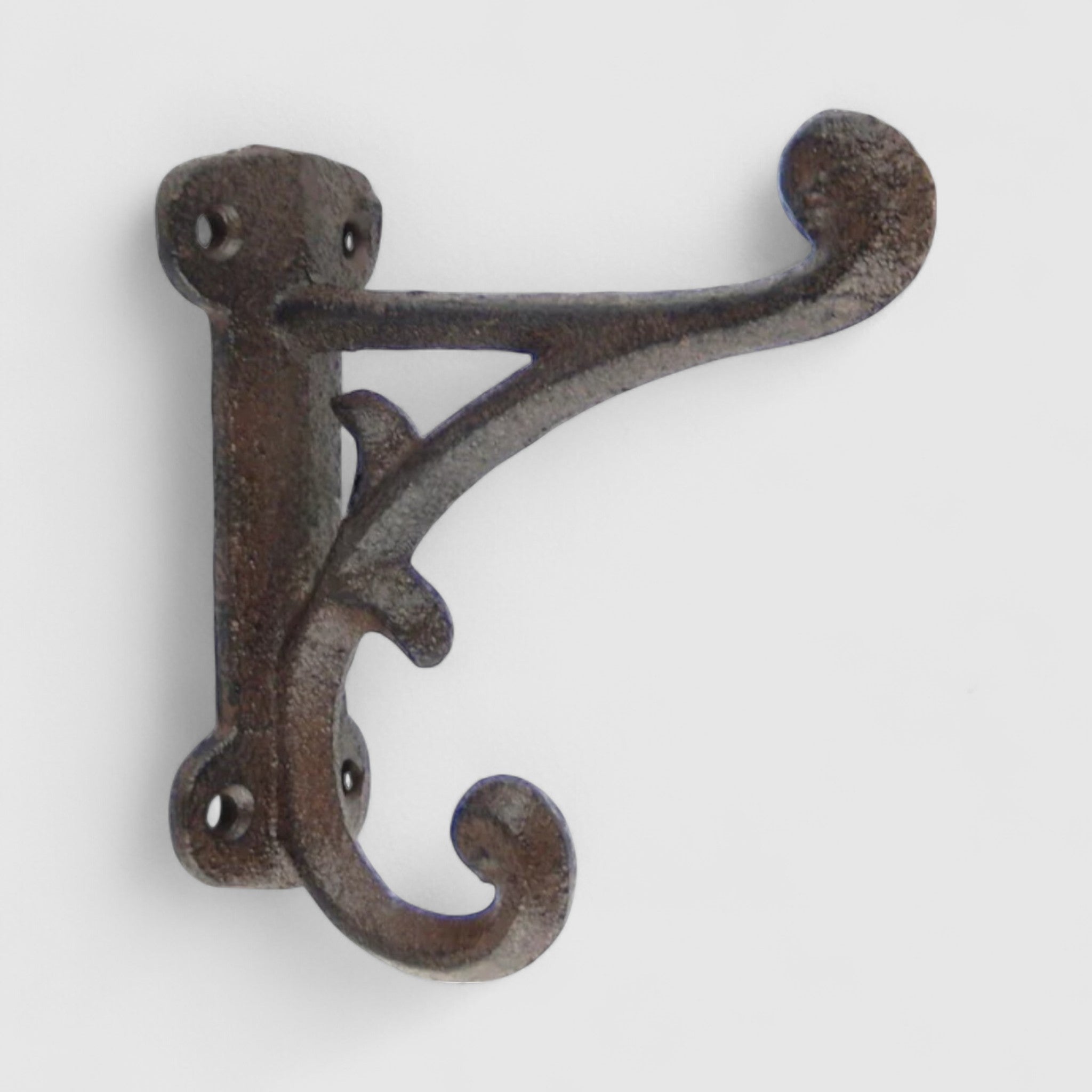 Decorative cast iron wall hook with curved ornate arms, weathered bronze patina finish