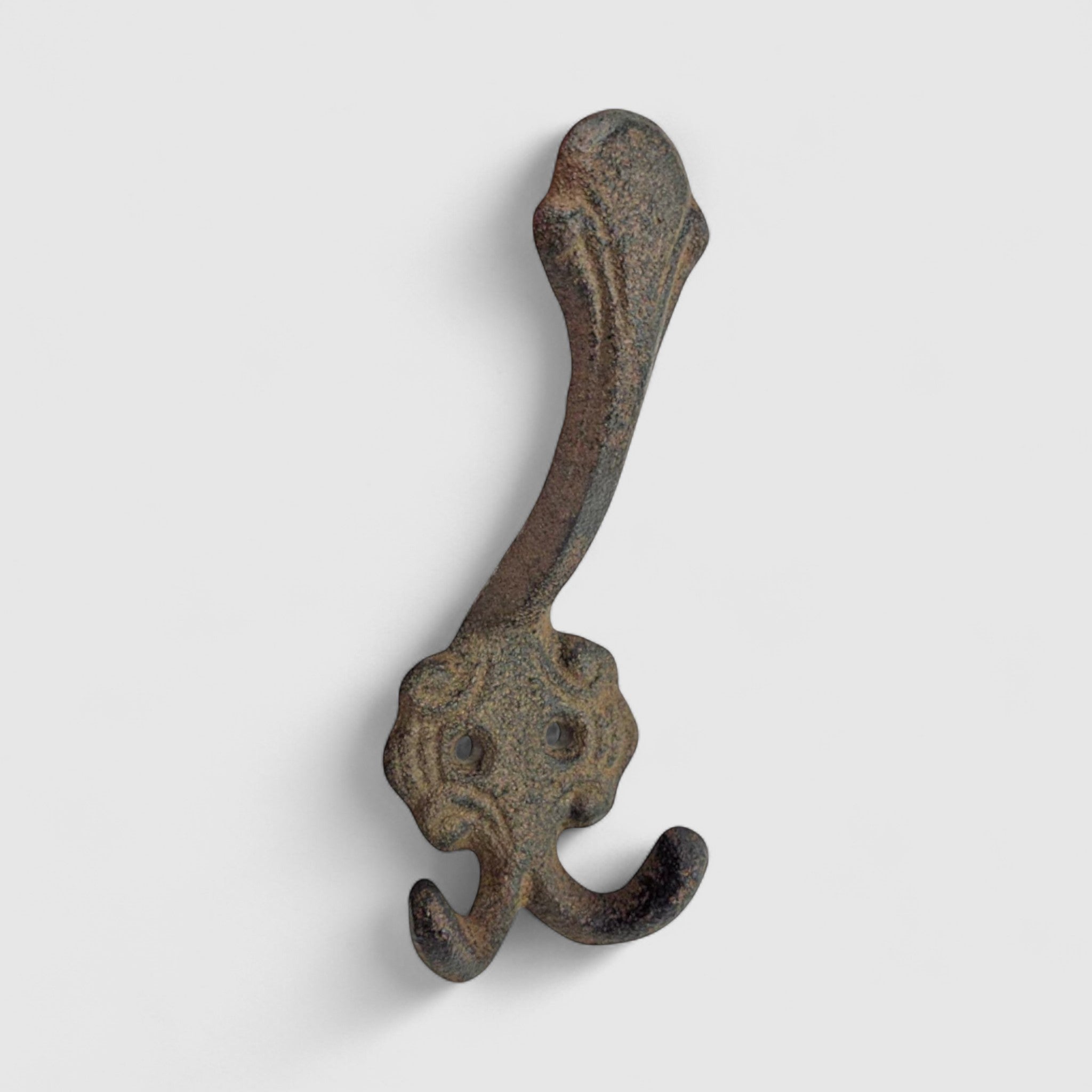 Antique cast iron decorative hook with dual prongs, weathered gray-brown rustic finish
