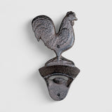 Antique gray cast iron rooster bottle opener shown from front with ornate base