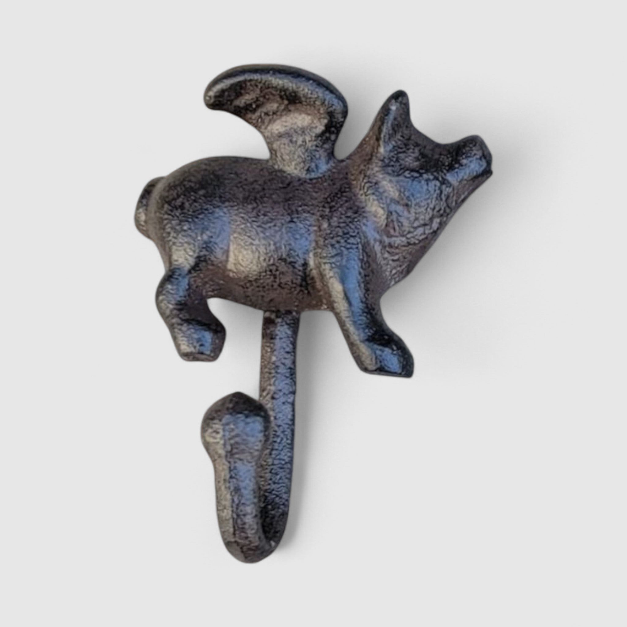 Antique black cast iron pig hook with weathered metallic patina, studio backdrop