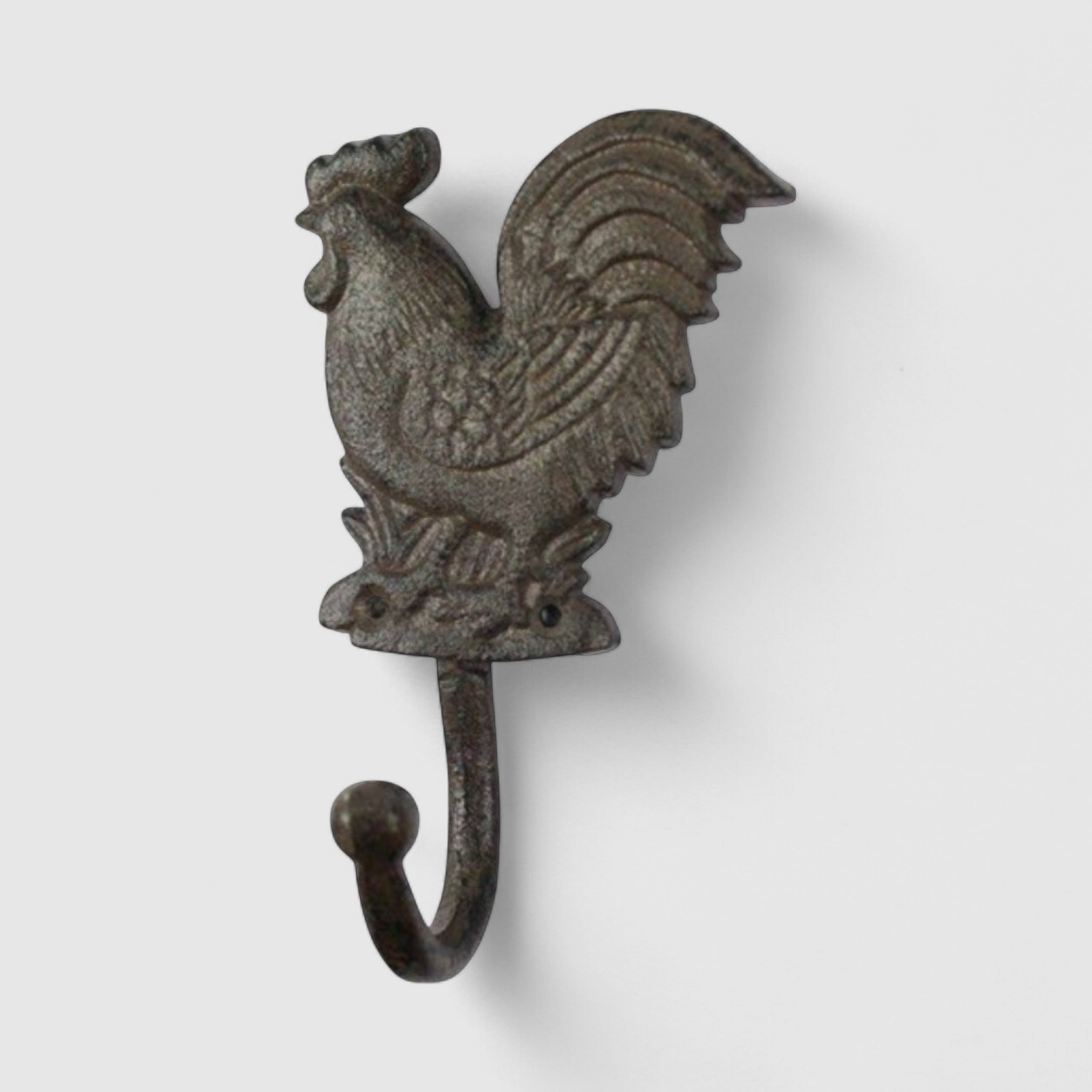 Gray cast iron rooster hook detail showing feathered wings and distressed rustic finish