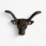 Rustic cast iron bull horn wall hook with aged patina finish showing side horn detail