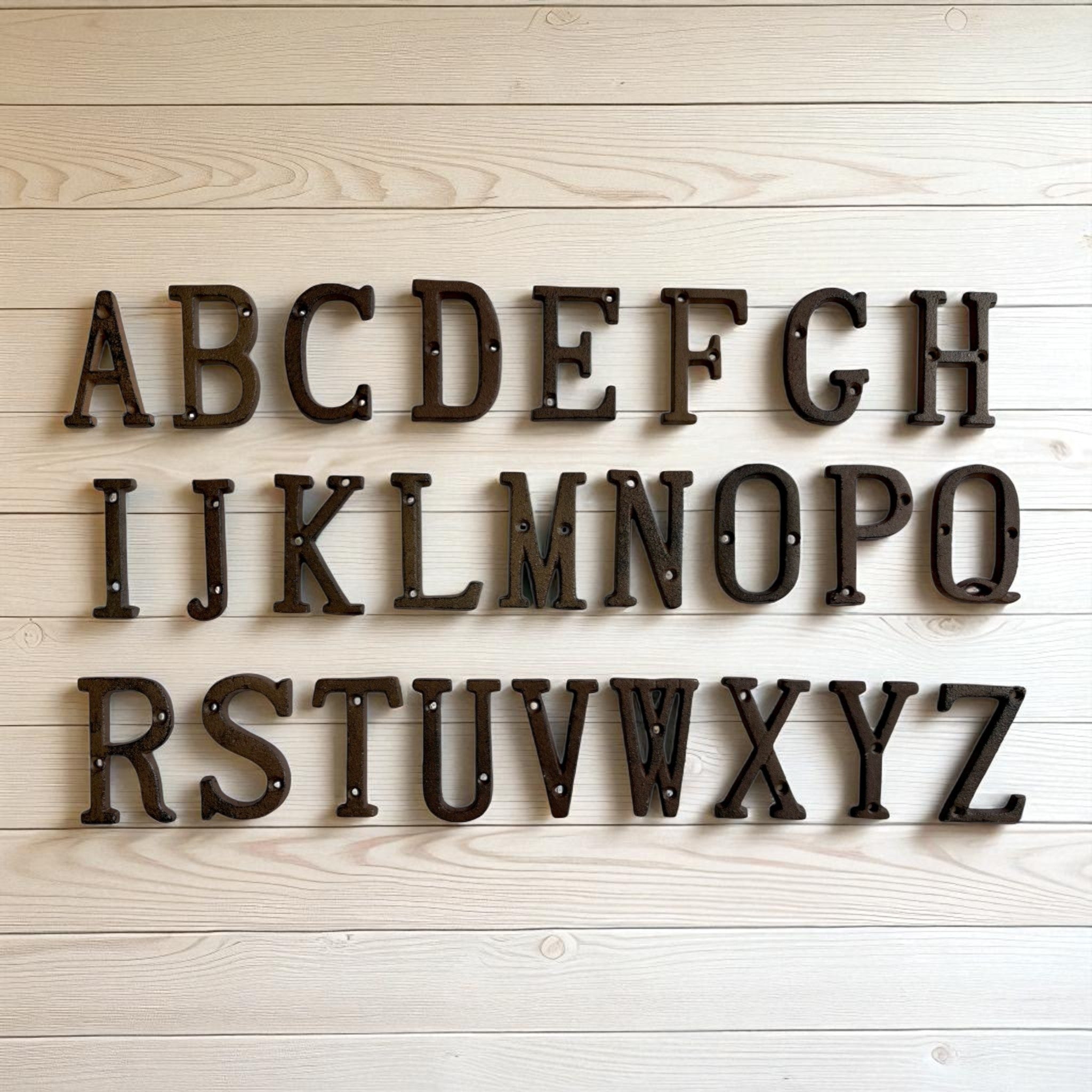 Cast iron alphabet letters A-Z, vintage brown finish on whitewashed wood wall decor