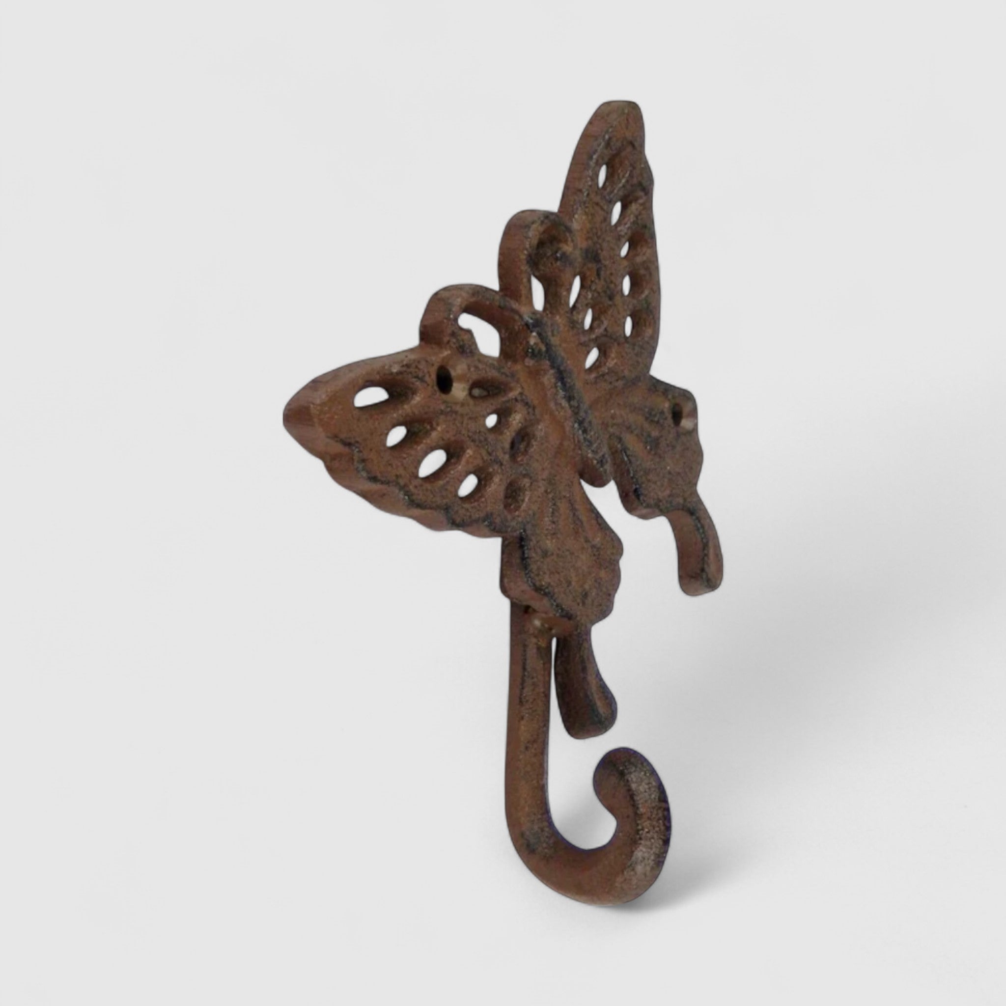 Ornate cast iron butterfly hook with oxidized patina showing three-dimensional sculptural wings and curved hook detail