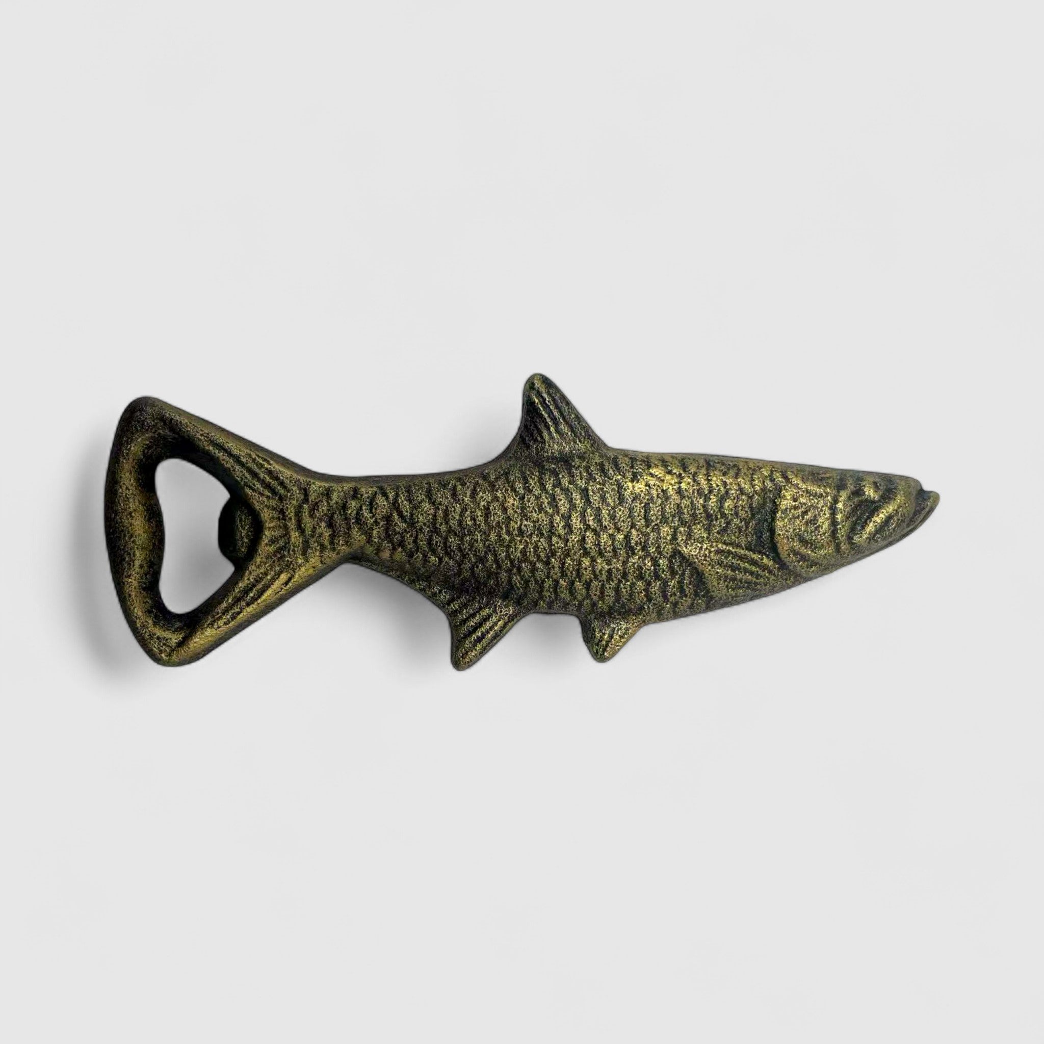 Antique gold cast iron fish bottle opener side profile showing detail and texture